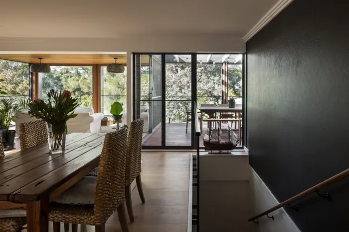 Dining area opening through glazed doors to a covered terrace, Coledale