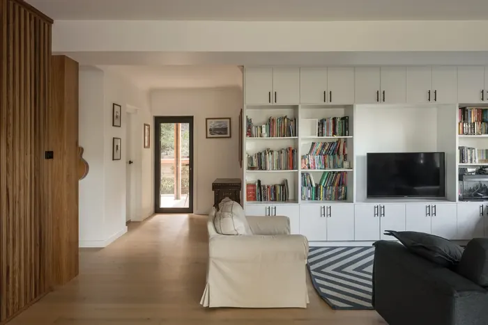 Refurbished living area with built-in shelving and vertical timber battens, Coledale