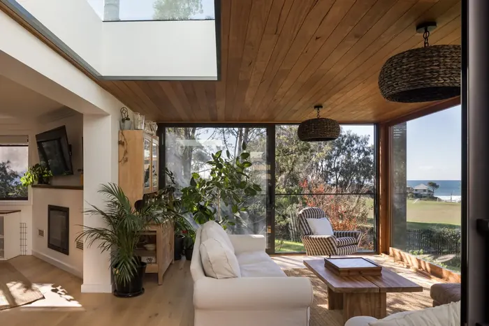 Living room under a skylight with timber ceiling and ocean views, Coledale