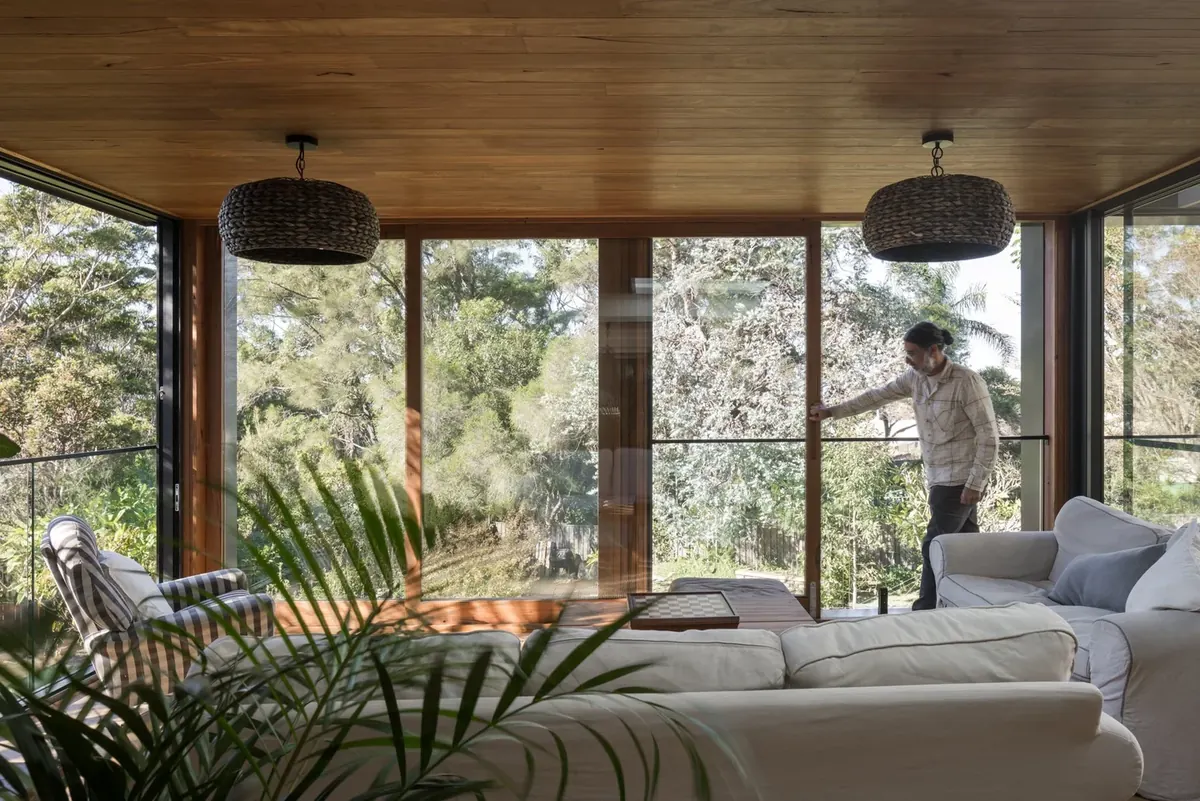 Renovated living room with a timber-lined ceiling and floor-to-ceiling glazing to the bush, Coledale