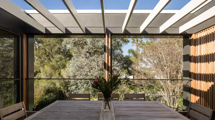 Covered dining terrace with timber pergola, part of a rear extension